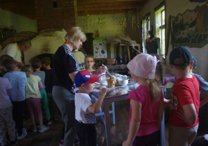 Dzieci przygotowują ciasto do wypieku bułek.