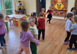 Dzieci tańczą poleczkę trzymając się za ręce.